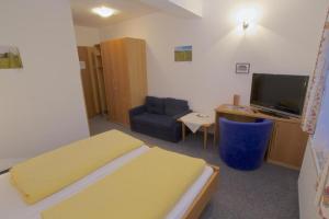 Zimmer mit einem Bett, einem TV und einem Stuhl in der Unterkunft Gasthof-Hotel zur Linde in Yspertal