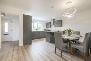 a kitchen and dining room with a table and chairs at Martello View - 3 Bedroom Holiday Home - Llanreath in Pembroke Dock