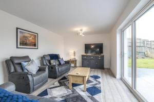 a living room with a couch and a tv at Martello View - 3 Bedroom Holiday Home - Llanreath in Pembroke Dock