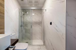 y baño con ducha y puerta de cristal. en TH Apartments by Como en Casa en A Coruña