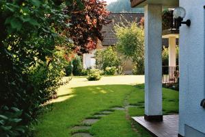 einen Garten mit einem Rasenhof mit einem Haus in der Unterkunft Ferienwohnungen im Herzen des Pfälzerwaldes in Elmstein