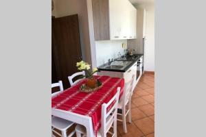 a kitchen with a table with a red table cloth at BARDOLINO,LAGO DI GARDA, APPARTAMENTO,vacanze in Bardolino