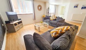 a living room with a couch and a tv at Contractor & Leisure Stays- FREE Parking with Great Location in Pembrokeshire