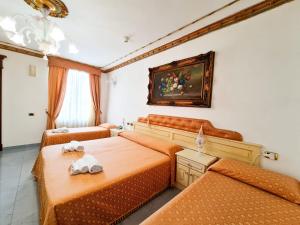 a bedroom with two beds and a painting on the wall at Euro Hotel Iglesias in Iglesias