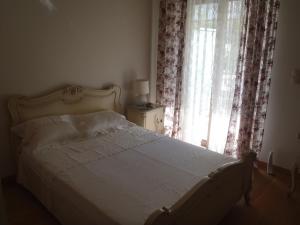 um quarto com uma cama e uma janela com cortinas em Modern Apartment with sea view in Saronida em Anavissos
