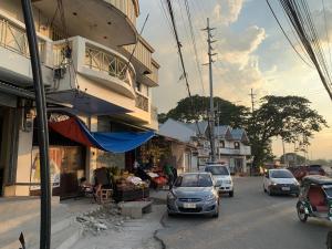 eine Straße mit neben einem Gebäude geparkten Autos in der Unterkunft La Riesa Dorm in Tarlac City