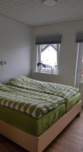 um quarto com uma cama num quarto com uma janela em Løkken centrum ferielejlighed-apartment 4F em Lokken