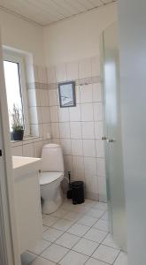Løkken centrum ferielejlighed-apartment 4F في لوكين: حمام مع مرحاض ومغسلة ونافذة