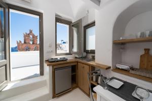 een keuken met een wastafel en een raam bij Astrea Suites Notus Dome House in Oia