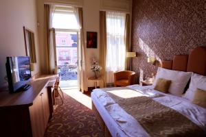 Hotel Zlatá Včela في دوماجليتسي: غرفه فندقيه سرير وتلفزيون