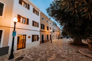 una strada acciottolata con luci di strada e edifici di Murada hotel a Ciutadella