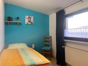 Ferienwohnung Parkblick في Dransfeld: غرفة نوم بسرير وجدار ازرق