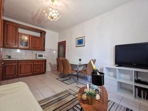 uma sala de estar com televisão e uma mesa com cadeiras em Apartment Lionel em Split