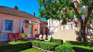 ein Haus mit einem Garten mit Stühlen und Pflanzen in der Unterkunft Vila Milenovic Rajacke Pivnice in Rajac