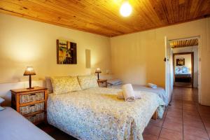 une chambre avec un lit et un plafond en bois dans l'établissement Baviaanskloof Guest Cottages, à Studtis