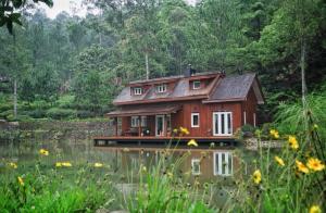 une maison assise au-dessus d'une masse d'eau dans l'établissement Mooi Lake House Luxury Villa, à Malabar