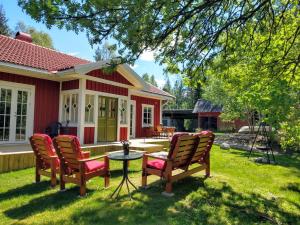 a house with chairs and a table in the yard at Stuga Glaskogen in Glava