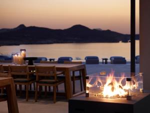 a fire pit on a patio with a table and chairs at Domes White Coast Milos, Adults Only - Small Luxury Hotels of the World in Mytakas