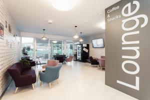 a restaurant with chairs and tables and a sign on the wall at Hotel Smart Liv'in in Böheimkirchen