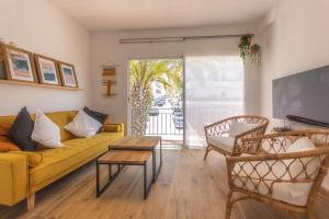 uma sala de estar com um sofá amarelo e uma mesa em Wonderful Views Terrace 3BR Cottage - BBQ - AC em Altea