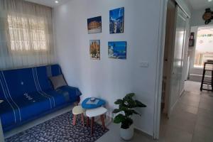 a living room with a blue couch and a table at Bolbol in Dar Salah Bey