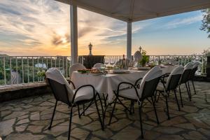 a long table with chairs on a patio at Villa Carolina Sorrento with sea view Jacuzzi and Pool in Sorrento