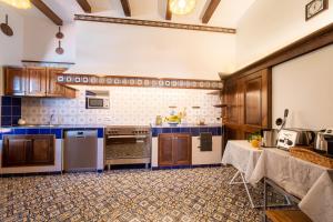 a large kitchen with wooden cabinets and blue counters at Villa Carolina Sorrento with sea view Jacuzzi and Pool in Sorrento