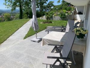 a patio with a table and chairs and an umbrella at Ferienwohnung Paradies in Nollingen
