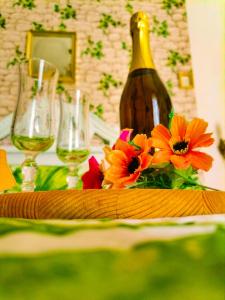 a table with glasses of wine and flowers on it at Francesca House in Atrani