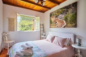 - une chambre avec un lit orné d'une peinture murale dans l'établissement Cottage da Paradinha: Passadiços do Paiva - Arouca, à Paradinha