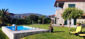 a swimming pool in a yard next to a house at Casa da Boa Vista em Viadal in Vale de Cambra