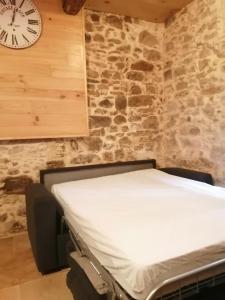 a bed in a room with a clock on the wall at Studio au centre ville de Carcassonne in Carcassonne