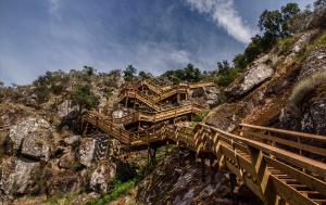 un ponte di legno sul fianco di una montagna di Arouca Passadiços Alojamentos & Jacuzzi a Arouca