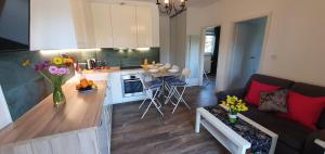 a kitchen and living room with a couch and a table at Kamień Bałtyku Apartament in Debina