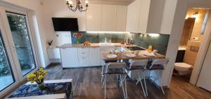 a kitchen with a table and some chairs in it at Kamień Bałtyku Apartament in Debina +2 photos