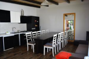 a kitchen with a table with chairs and a sink at Vila Ardelean in Sînmartin