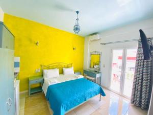 a bedroom with a bed and a yellow wall at Villa Antonis in Parga