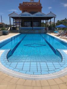 a large swimming pool with a building in the background at Frank Apartments in Amoudara Herakliou