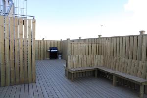 een houten terras met een bank en een hek bij Tryggvabraut 24 One Bedroom Apartment in Akureyri