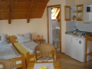 a room with a kitchen with a table and chairs at Mirtill Apartmanház in Hévíz