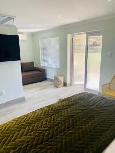 a bedroom with a large bed and a couch at Impa-Lala Country Estate in Bloemfontein