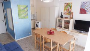 uma sala de estar com uma mesa de jantar e uma cozinha em APPARTAMENTO SAN MARCO em Lido di Jesolo