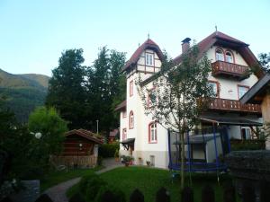 una casa blanca con parque infantil en el patio en Apartments Alte Villa, en Garmisch-Partenkirchen