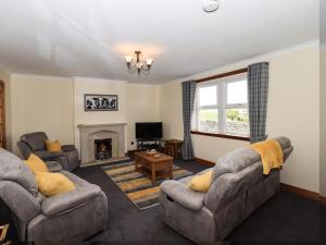 a living room with two couches and a fireplace at Challochmun Bungalow in Newton Stewart