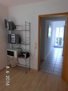 Zimmer mit einem Regal mit einer Mikrowelle und einer Tür in der Unterkunft Ferienwohnung Roder in Marburg an der Lahn