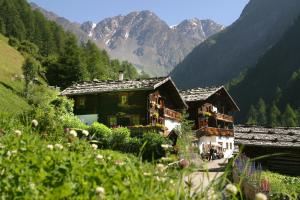 a house in a valley with mountains in the background at Dorfblick Appartements & Rooms in Senales