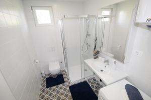 a white bathroom with a shower and a sink at Holiday house PUNTA Umag II in Umag +21 photos