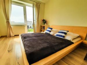 a bedroom with a large bed with blue and white pillows at Malmaris in Władysławowo