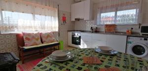 a kitchen with a table and a kitchen with a washing machine at Moradia santa comba in Santa Comba Dão