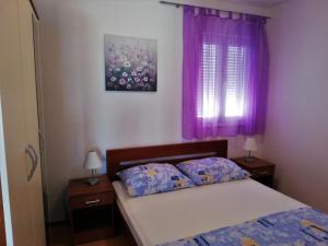 a bedroom with a bed with purple curtains and purple pillows at Apartment in Sevid with Seaview, Balcony, Air condition, WIFI (4755-4) in Sevid